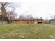 Spacious backyard with well-maintained grass, brick home and wooden fence at 518 Wedgewood Dr, Anderson, IN 46013