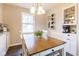 Bright dining area with a wooden table, white chairs, and a charming display cabinet at 518 Wedgewood Dr, Anderson, IN 46013