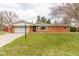 Charming single-story brick home with attached garage, lovely front yard, and mature trees in a peaceful setting at 518 Wedgewood Dr, Anderson, IN 46013