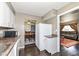 View of kitchen featuring white cabinets, dark countertops, and modern appliances that flow into the dining and living room at 5414 Honey Comb Ln, Indianapolis, IN 46221