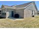 A cozy backyard featuring a well-maintained lawn, a small patio, and a brick exterior on a sunny day at 6480 E Walton Dr, Camby, IN 46113