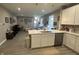 Open-concept kitchen with white cabinetry, island with sink, and stainless steel appliances at 6480 E Walton Dr, Camby, IN 46113