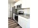 Modern kitchen features stainless steel appliances, white cabinetry, and granite countertops at 702 Eberhart Dr, Shelbyville, IN 46176