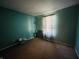Empty bedroom with teal walls, dark carpet, a small window with curtains, and basic amenities at 734 W 9Th St, Greenfield, IN 46140