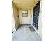 Covered front entry featuring a black front door, small window, brick accents, and concrete flooring at 734 W 9Th St, Greenfield, IN 46140