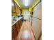 Galley kitchen with white appliances, wood cabinets, laminate counters, and a white door at the end of the hall at 734 W 9Th St, Greenfield, IN 46140