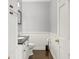 Charming powder room boasts wainscoting, dark countertop vanity, and elegant decorative touches at 7780 Paw Paw Dr, Nineveh, IN 46164