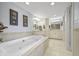 Luxurious bathroom with a large soaking tub, double vanities, and elegant fixtures, offering a spa-like experience at 7780 Paw Paw Dr, Nineveh, IN 46164