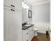 Powder room featuring a dark countertop, traditional fixtures, and a decorative 'Please Wait' sign at 7780 Paw Paw Dr, Nineveh, IN 46164