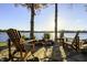 Inviting stone fire pit area with Adirondack chairs overlooking the lake, perfect for outdoor entertaining at 7780 Paw Paw Dr, Nineveh, IN 46164