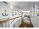 Upstairs hallway with white walls, wood floors, and nautical decor leading to the living room at 7780 Paw Paw Dr, Nineveh, IN 46164