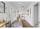 Hallway with wood floors and nautical decor leading to the kitchen, stairs, and exterior door at 7780 Paw Paw Dr, Nineveh, IN 46164