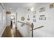 Upstairs hallway with nautical decor, hardwood floors, and a view of the kitchen at 7780 Paw Paw Dr, Nineveh, IN 46164