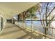 Spacious covered patio overlooking the lake with white railing and wood decking offers scenic views of the waterfront at 7780 Paw Paw Dr, Nineveh, IN 46164