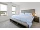 Bright bedroom with neutral tones, featuring large windows and a comfortable bed with a gray upholstered headboard at 802 N Meridian St # 204, Indianapolis, IN 46204