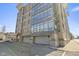 Modern building featuring expansive windows, multiple garage doors, and ample parking spaces at 802 N Meridian St # 204, Indianapolis, IN 46204