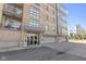 Modern building entrance featuring glass doors, street view, and garages at 802 N Meridian St # 204, Indianapolis, IN 46204