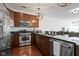 Modern kitchen featuring stainless steel appliances, dark wood cabinets, and granite countertops at 802 N Meridian St # 204, Indianapolis, IN 46204