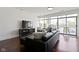 Cozy living room features a black leather sofa and large windows with a view of the city at 802 N Meridian St # 204, Indianapolis, IN 46204