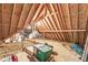 Unfinished attic space with exposed rafters and beams used for storage, lit with a single lightbulb at 8425 N Halyard N Way, Indianapolis, IN 46236