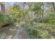A peaceful path winds through a wooded backyard, with natural foliage creating a serene atmosphere at 8425 N Halyard N Way, Indianapolis, IN 46236