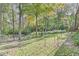 The backyard offers a lush lawn bordered by mature trees, providing a serene and private outdoor space at 8425 N Halyard N Way, Indianapolis, IN 46236