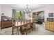 Dining room with wood table, chairs, chandelier, and natural light from the large window at 8425 N Halyard N Way, Indianapolis, IN 46236
