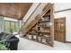 Staircase with custom bookcase and decorations, wood ceiling, and view of the living room at 8425 N Halyard N Way, Indianapolis, IN 46236