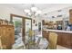 Eat-in kitchen with glass dining table, oak cabinetry, stainless steel appliances, and pass-through to the screened-in porch at 8425 N Halyard N Way, Indianapolis, IN 46236