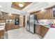 Kitchen features wood cabinetry, stainless steel refrigerator and appliances, and tile floors at 8425 N Halyard N Way, Indianapolis, IN 46236