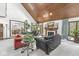 Cozy living room with vaulted wood ceiling, fireplace, and natural light from the large windows at 8425 N Halyard N Way, Indianapolis, IN 46236
