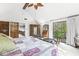 A naturally lit main bedroom featuring a vaulted ceiling, ceiling fan and sliders to the back deck at 8425 N Halyard N Way, Indianapolis, IN 46236