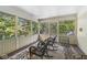 Screened porch with natural light, multiple wicker rocking chairs, and wood floors covered with a rug at 8425 N Halyard N Way, Indianapolis, IN 46236