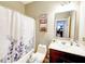 Cozy bathroom featuring a shower with a patterned curtain, a sink vanity, and decorative accents at 8729 Dorill Creek Ln, Indianapolis, IN 46259