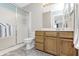 Bright bathroom features a glass shower door, wood vanity, and a large mirror at 8820 Yardley Ct # 101, Indianapolis, IN 46268