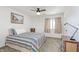 Cozy bedroom featuring a striped quilt, ceiling fan, and ample natural light from the window at 8820 Yardley Ct # 101, Indianapolis, IN 46268