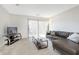 Comfortable living room featuring a large leather sectional couch, glass coffee table, and sliding glass doors for ample light at 8820 Yardley Ct # 101, Indianapolis, IN 46268