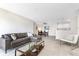 Open concept living space flows into dining area with modern sectional and kitchen access with breakfast bar seating at 8820 Yardley Ct # 101, Indianapolis, IN 46268