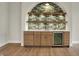 Wet bar with green tile backsplash and stainless mini-fridge in finished basement at 908 Oak Terrace Rd, Westfield, IN 46074