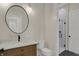 Modern bathroom featuring a stylish round mirror, sleek vanity, toilet and frameless glass shower at 908 Oak Terrace Rd, Westfield, IN 46074