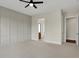 Spacious bedroom with neutral walls, white trim, a ceiling fan, and doorways to an ensuite bathroom and walk-in closet at 908 Oak Terrace Rd, Westfield, IN 46074