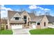 Beautiful brick home featuring a three-car garage, manicured lawn, and complementary gray and white trim at 908 Oak Terrace Rd, Westfield, IN 46074
