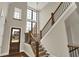 Grand foyer featuring high ceilings, a staircase with wooden banister, and natural light streaming through large windows at 908 Oak Terrace Rd, Westfield, IN 46074