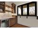 A modern kitchen with marble countertops, built in beverage cooler, with view from exterior window at 908 Oak Terrace Rd, Westfield, IN 46074