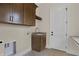 Functional laundry room with modern fixtures, built-in cabinets, sink and stylish tile floor at 908 Oak Terrace Rd, Westfield, IN 46074