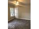 This bedroom has a ceiling fan, neutral walls, new carpet, and a large window at 923 N Denny St, Indianapolis, IN 46201