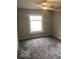 Cozy bedroom with new carpet, neutral walls, ceiling fan and a large window at 923 N Denny St, Indianapolis, IN 46201
