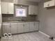 Functional kitchen with white cabinetry, tile flooring and good natural light at 923 N Denny St, Indianapolis, IN 46201