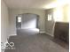 Open-concept living room features neutral paint, new carpet, a fireplace and an arched doorway at 923 N Denny St, Indianapolis, IN 46201