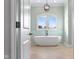 View of a modern bathroom with a soaking tub under an arching picture window at 995 Westlake Hills Dr, Columbus, IN 47201